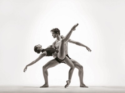 Harrison performs a demi-plié in second position as he holds a ballerina as she back bends into his arms while on point, as well as performing a leg extension.