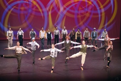 Ballet dancers on stage as seven perform turns while the other dancers are stand behind them at the back of the stage.
