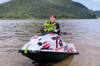 Jonty smiles for photo as he sits on jet ski in the water.
