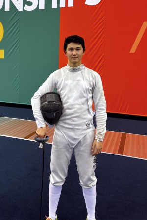 Ryan stand in his fencing kit.