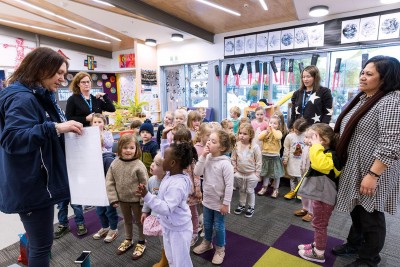 Staff members and Pre-school children stand on the matt as the start their day with a hui.