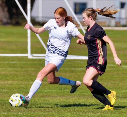 1st XI Girls' football player drippling with the ball during final match.