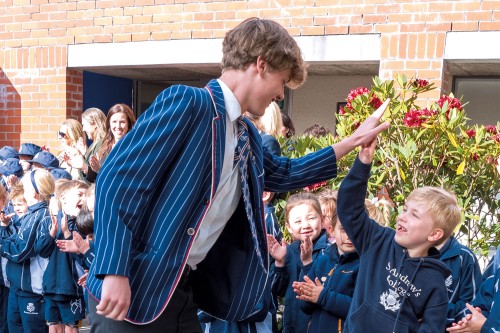 Year 13 leaver high-fiving Preparatory School student during the Leavers' Parade.