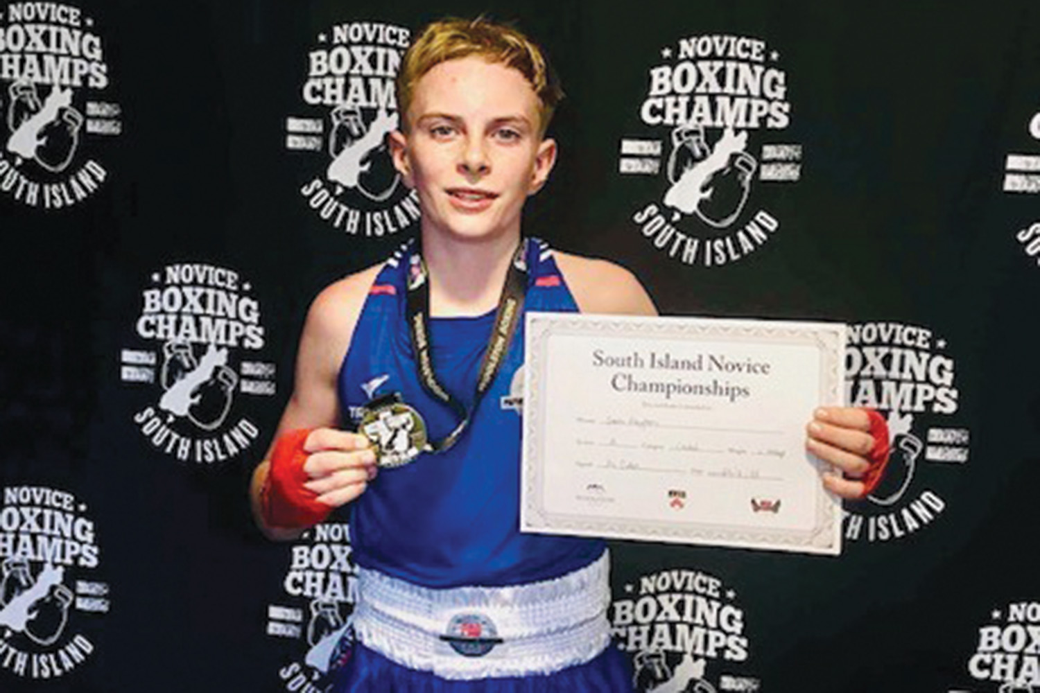 St Andrew's College student Sam Payton holding his boxing medal and certificate.