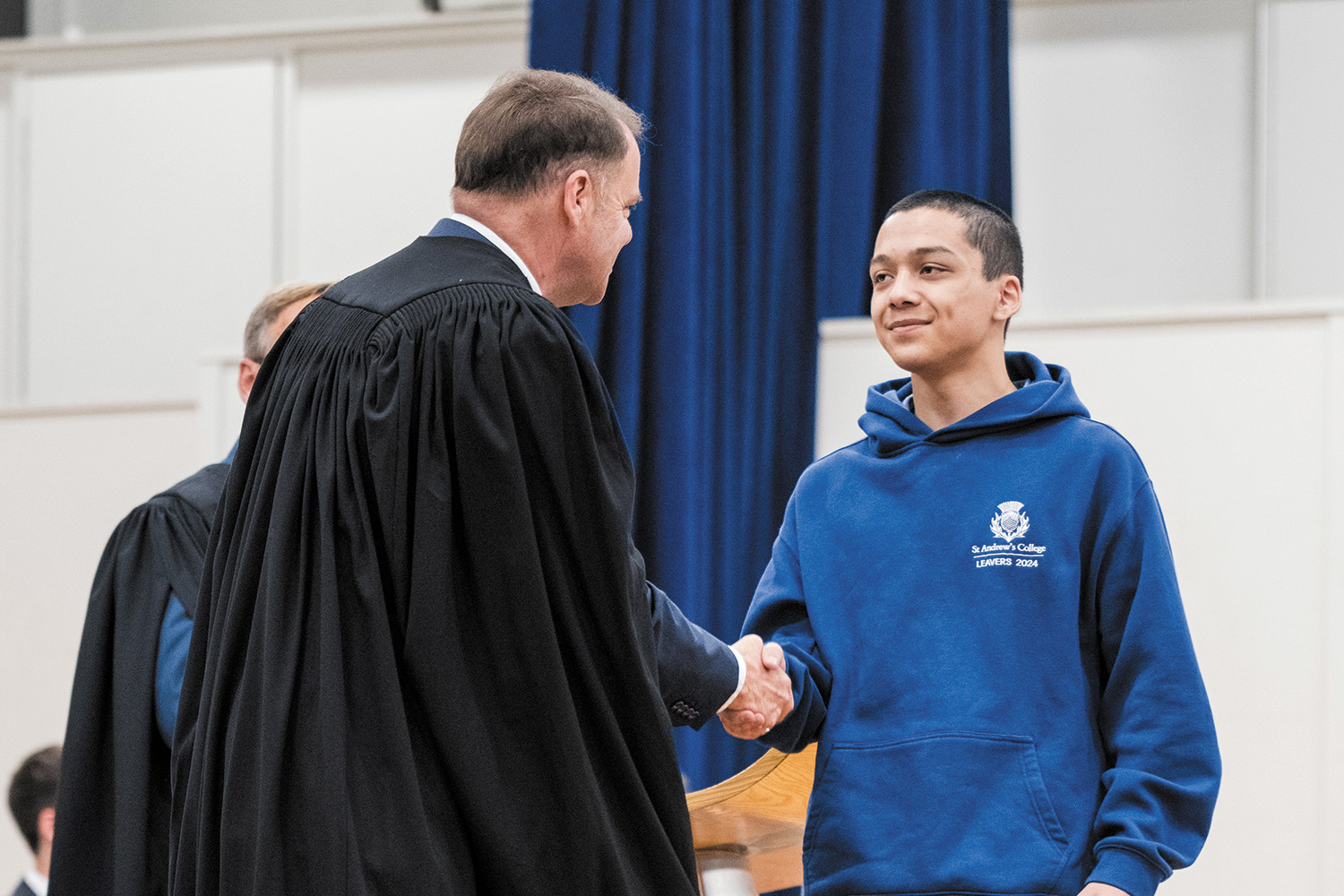 St Andrew's College Rector and a student at the 2025 Academic Assembly.