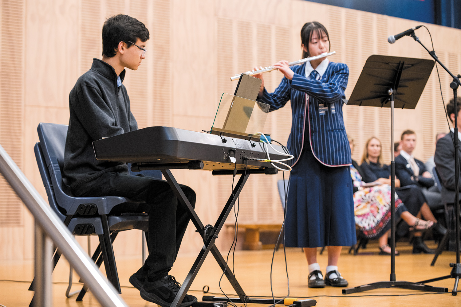 St Andrew's College Old Collegian Sea-am Thompson and student Miu Kim performing at the 2025 Academic Assembly.