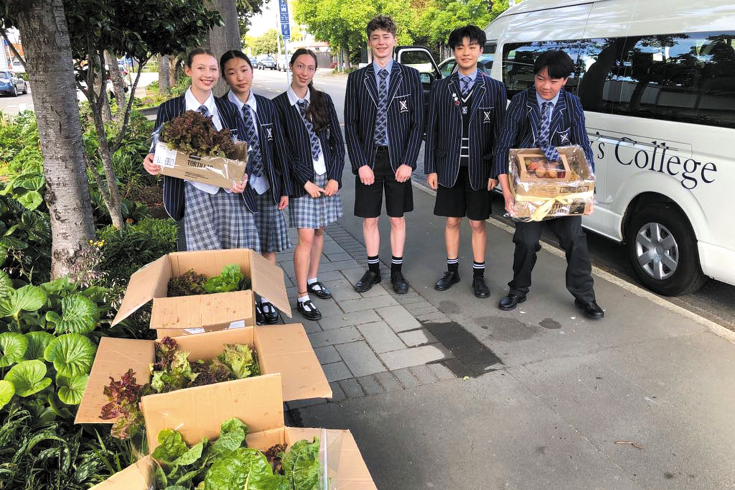 St Andrew's College students delivering fresh vegetables grown on campus and muffins to St Ambrose Church.