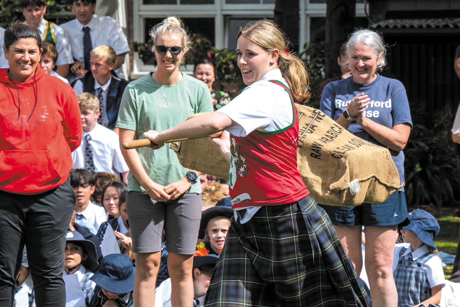 St Andrew's College student participating in wheat sheaf tossing during the 2025 Highland Games.