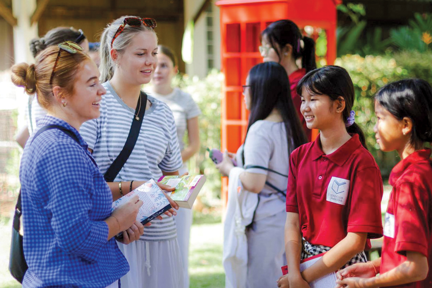 Two St Andrew's College students interacting with Cambodian children