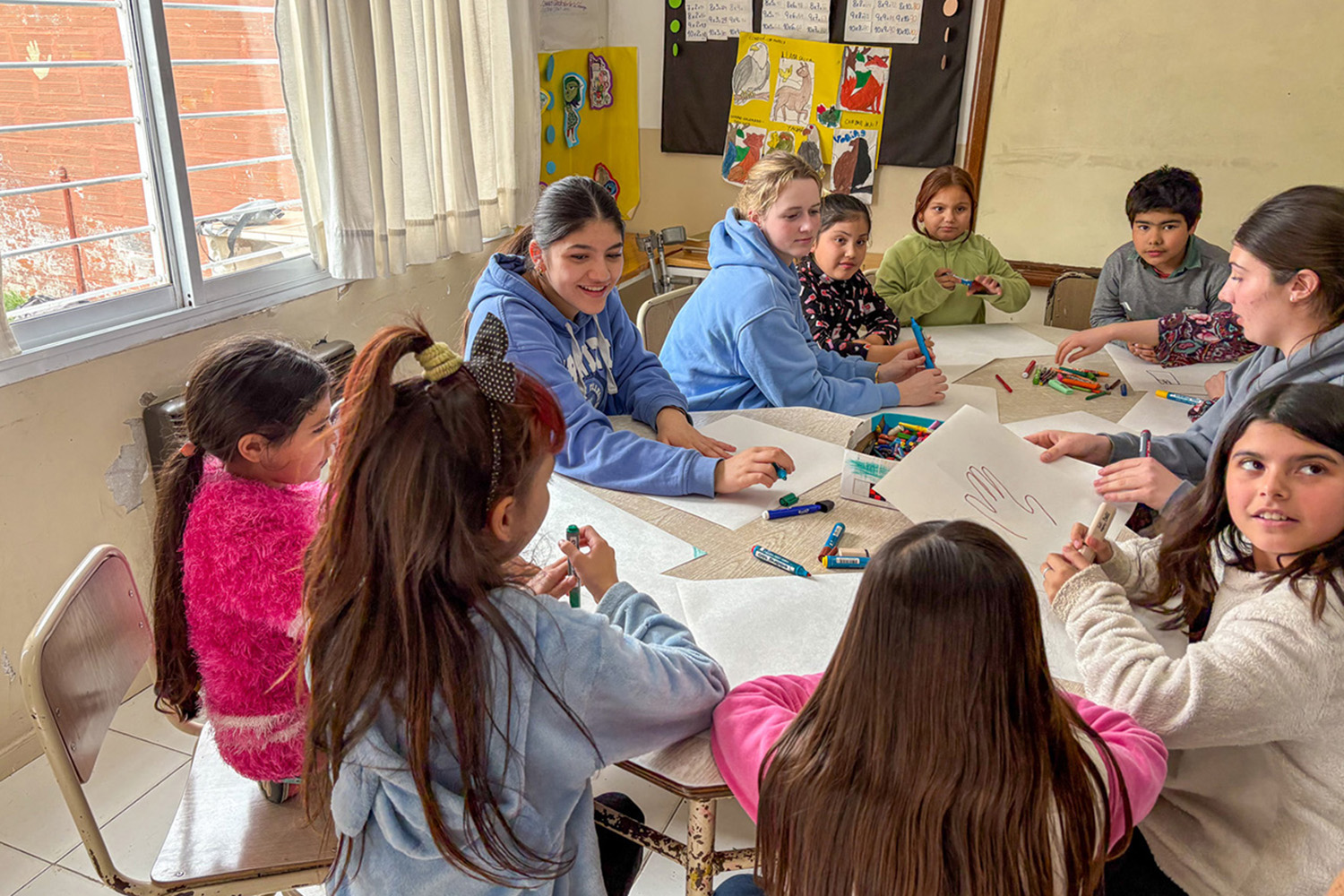 St Andrew's College students drawing with children at Manos Abiertas, a volunteer organisation in Buenos Aires, Argentina