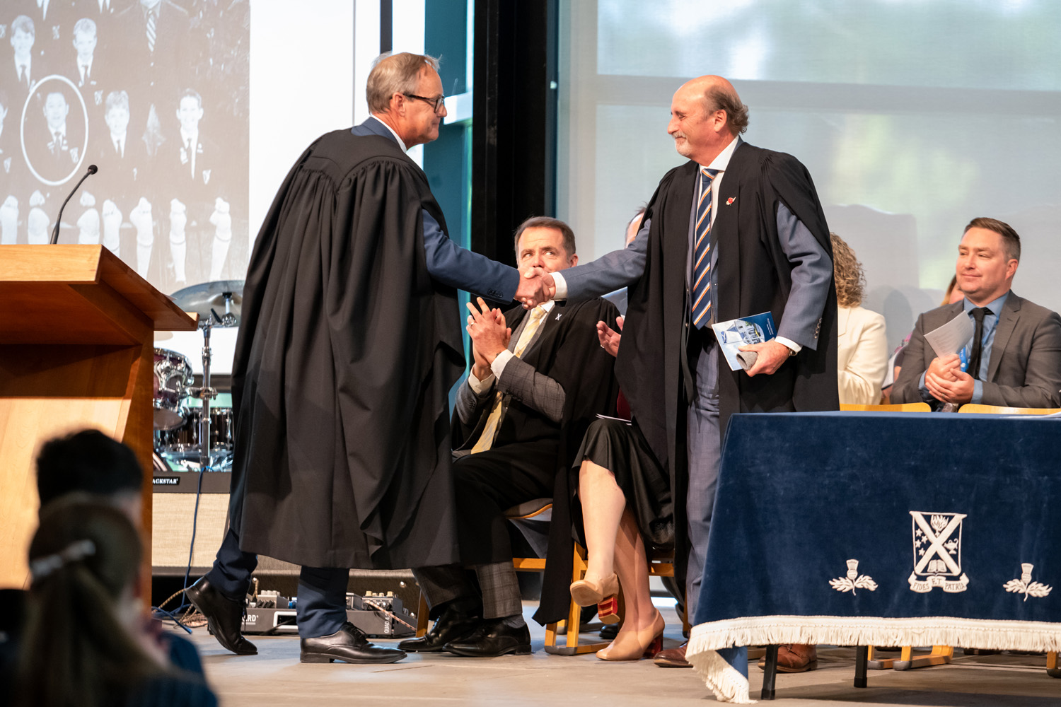St Andrew's College Principal of Secondary School and retiring Principal of Preparatory School shaking hands at the 2025 Leavers' Assembly.