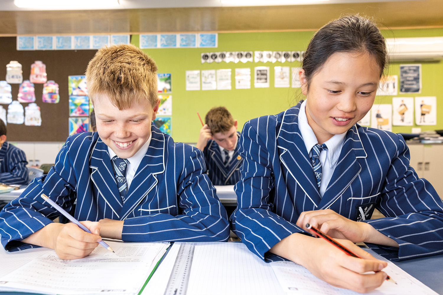 Two St Andrew's College students writing.