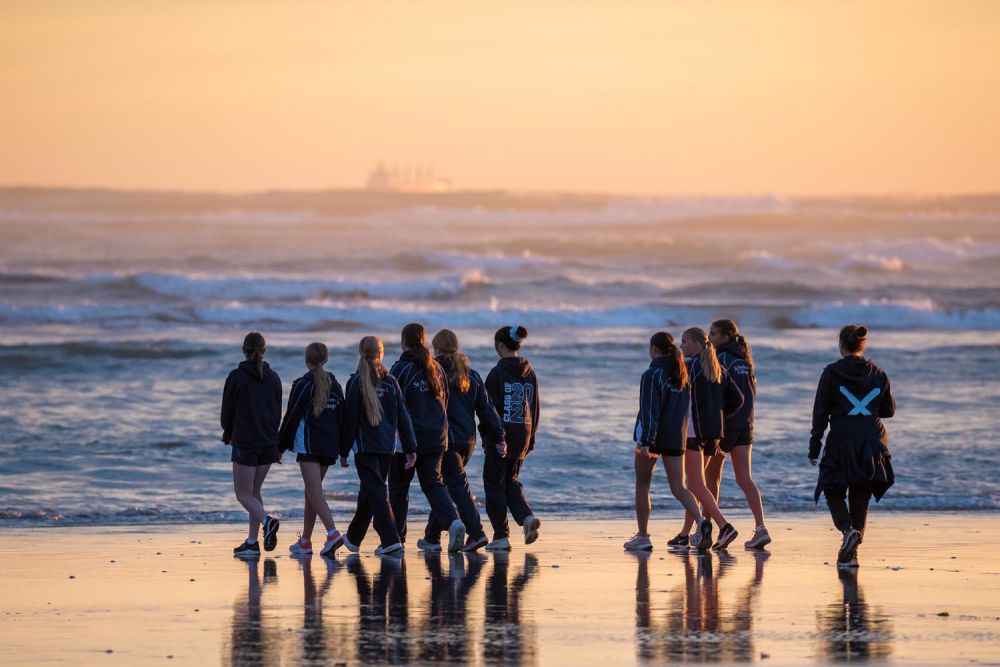 A group of St Andrew's College students walking at the beach