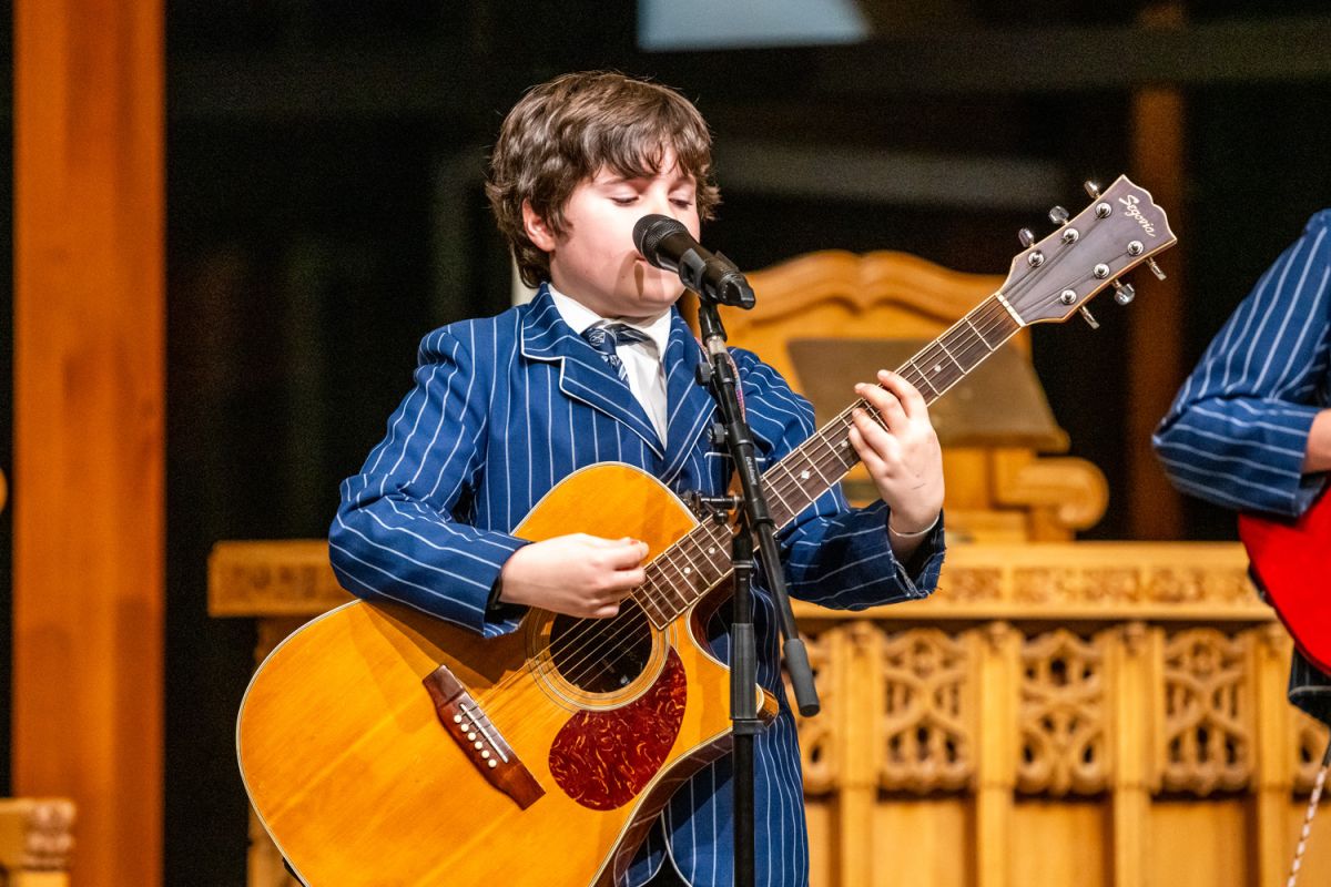 St Andrew's College student playing the guitar