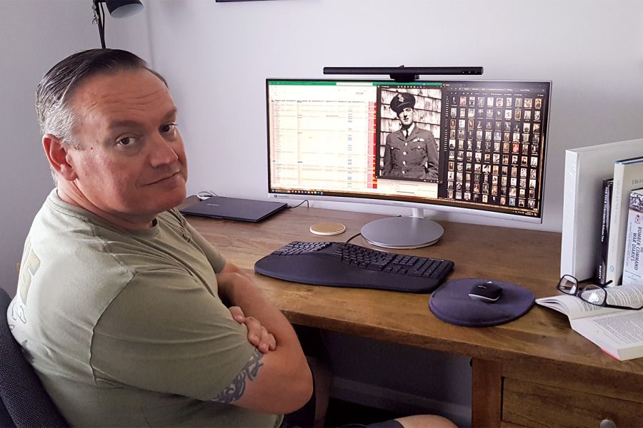 St Andrew's College Old Collegian Daryll Fell sitting at his computer with his research project.