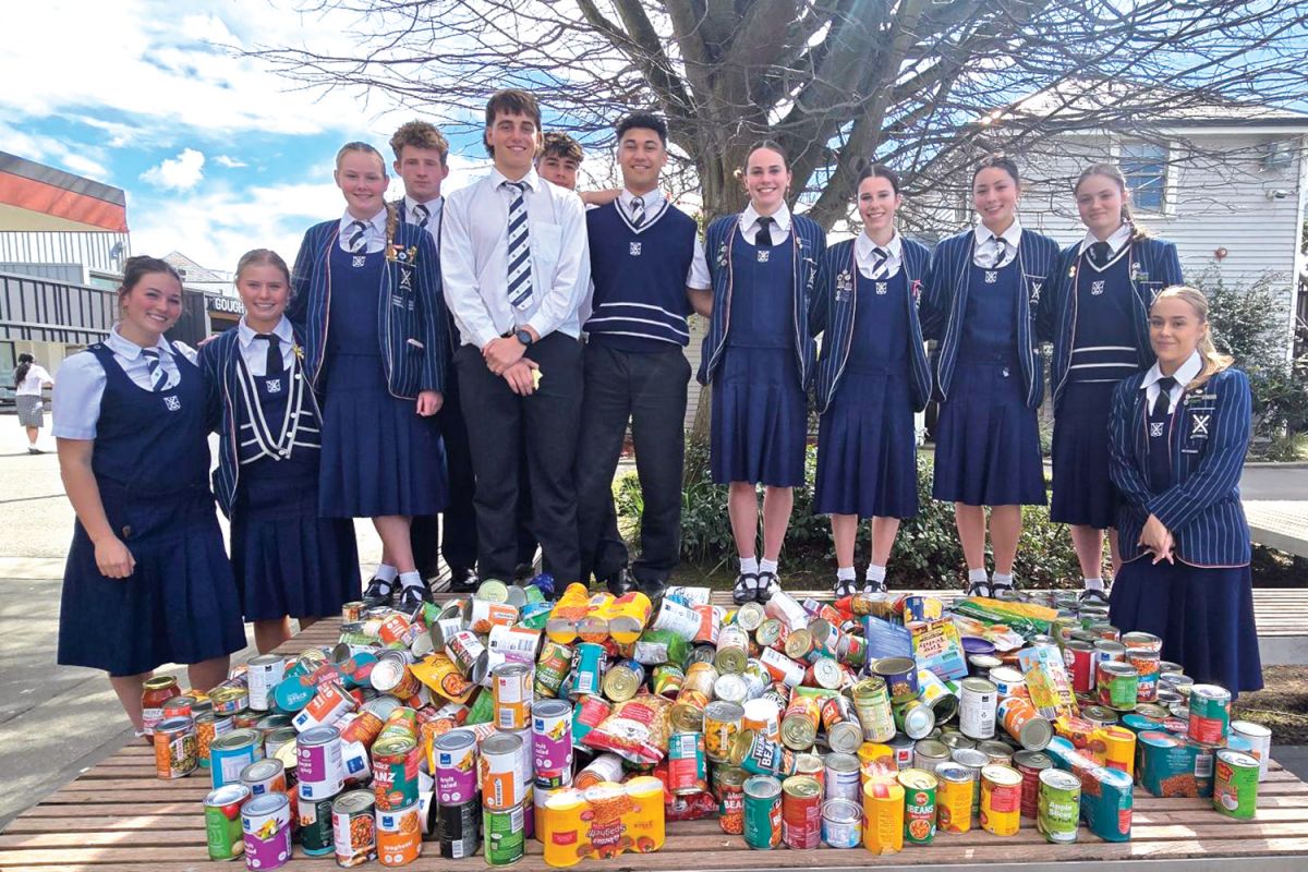 St Andrew's College students displaying the cans of food collected through the efforts of students and staff to donate to the Hoon Hay Foodbank.