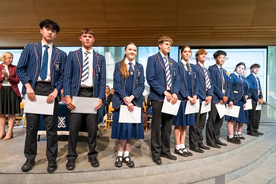 St Andrew's College students holding certificates at the 2025 Leavers' Assembly.