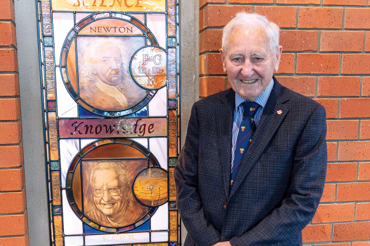 Professor Roy Kerr beside the stained glass window honouring him in the Centennial Chapel.