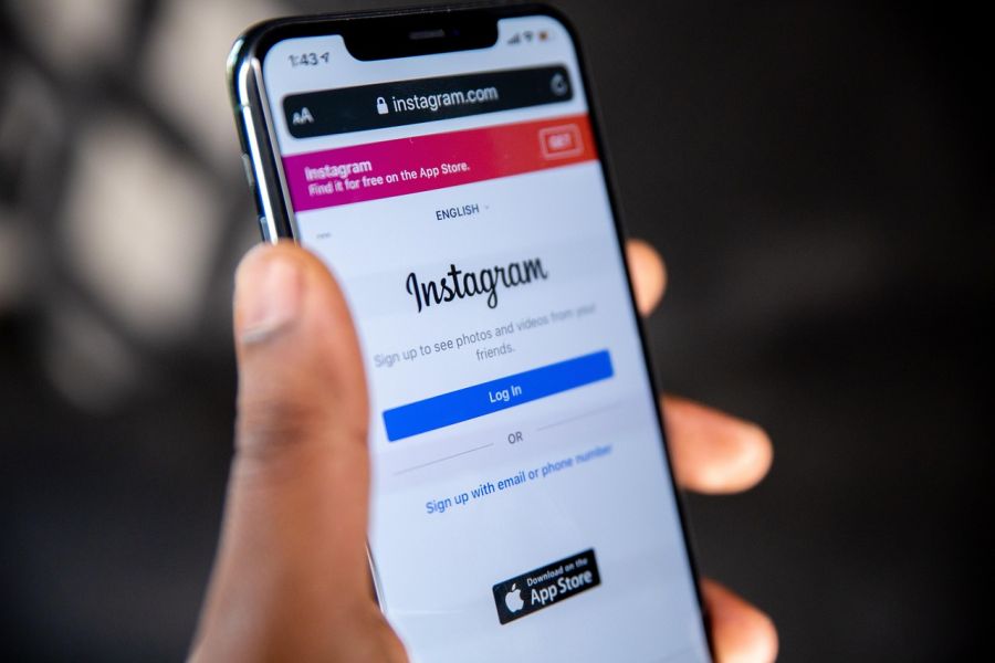 Hand holding phone with the Instagram app login.