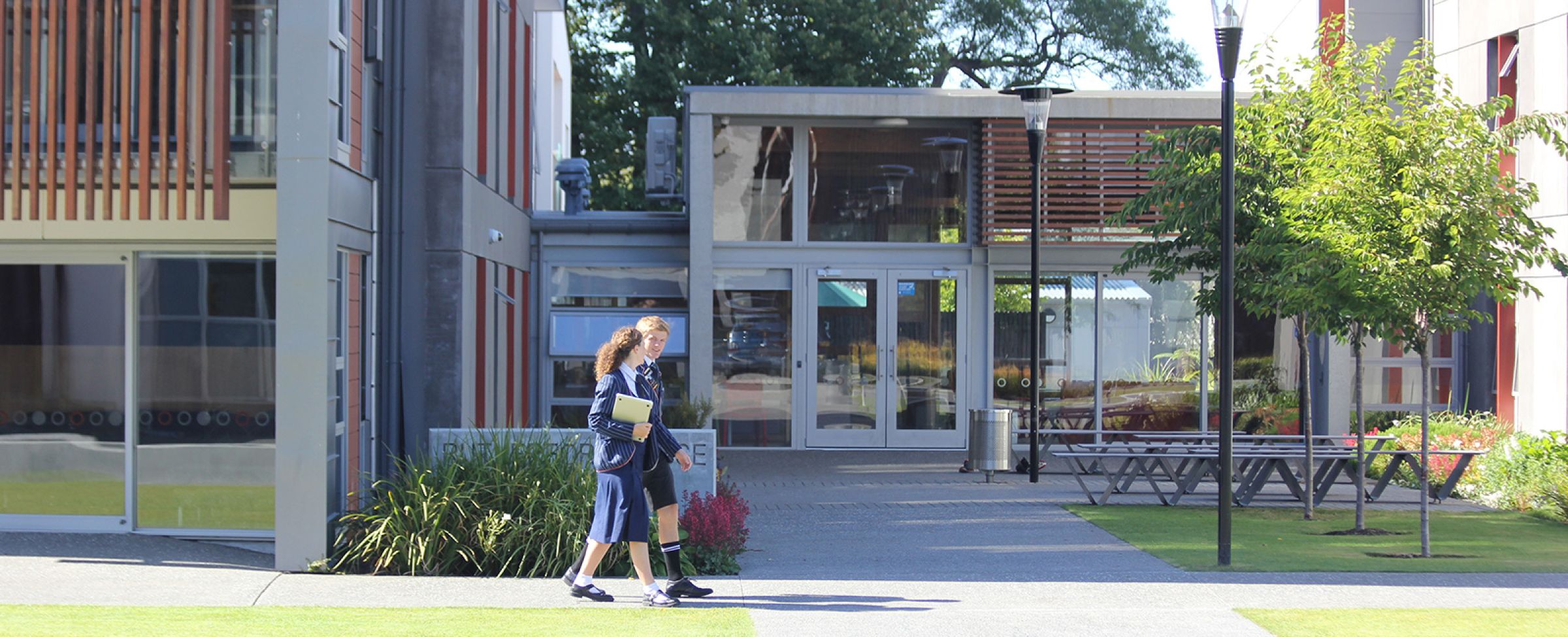 Two students walking outside boarding house.
