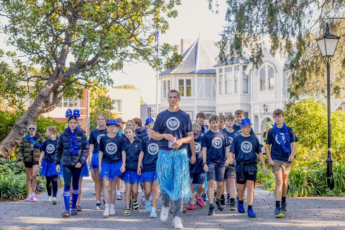 Boarding students in house colours on grounds.
