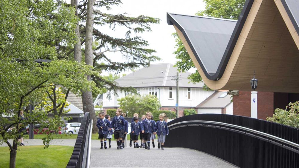 St Andrew's College Centennial Chapel exterior with children walking over the bridge