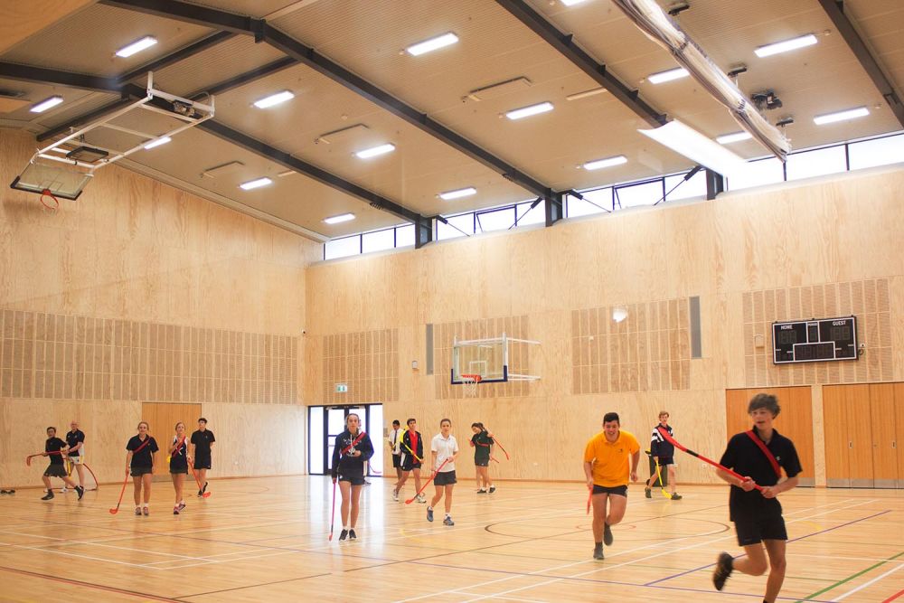 Gym 2 court with students playing hockey