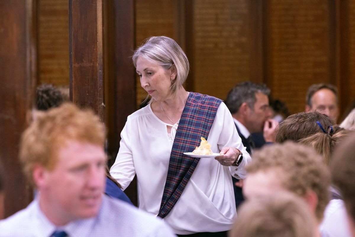 Volunteer serving students at the Boarders Dinner.