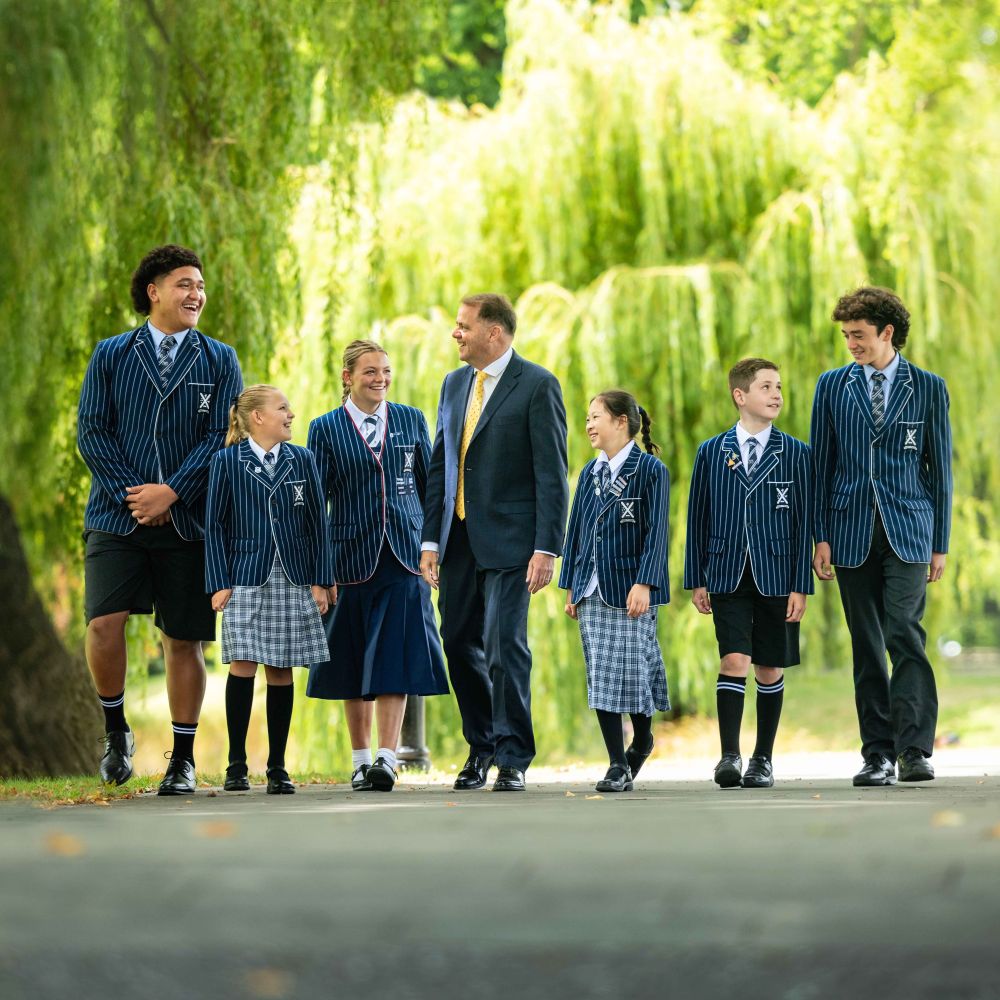 Mark Wilson, Rector, walking with group of students through the campus