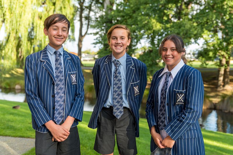 Smiling students in school grounds.