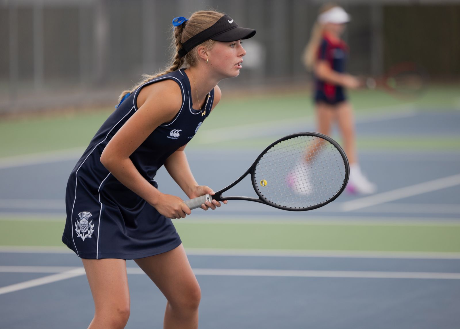 St Andrew's College female student playing tennis with bat in hand