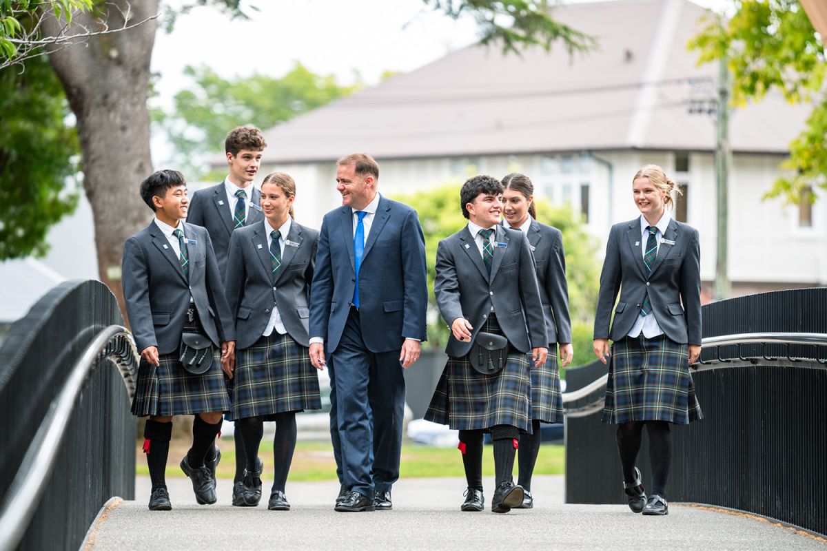 St Andrew's College Rector, Mark Wilson walking on the Turley Bridge at campus with the 2025 Heads of College.