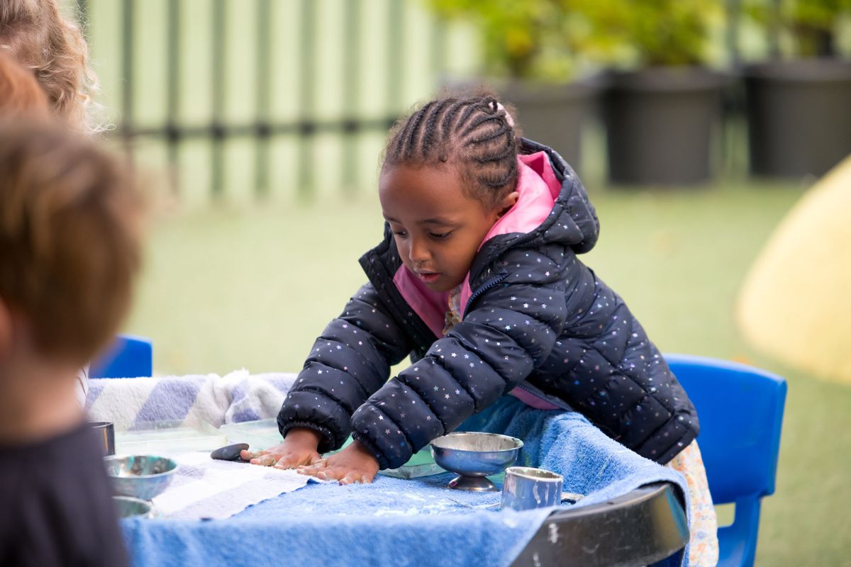 Pre-school child playing with paint.