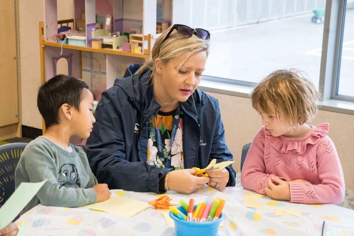 Pre-school children doing crafts with a teacher.