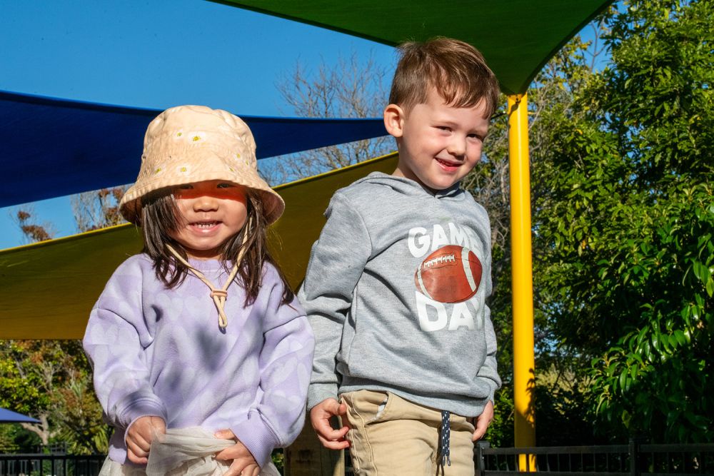 Two children playing outside at the St Andrew's College Pre-school.