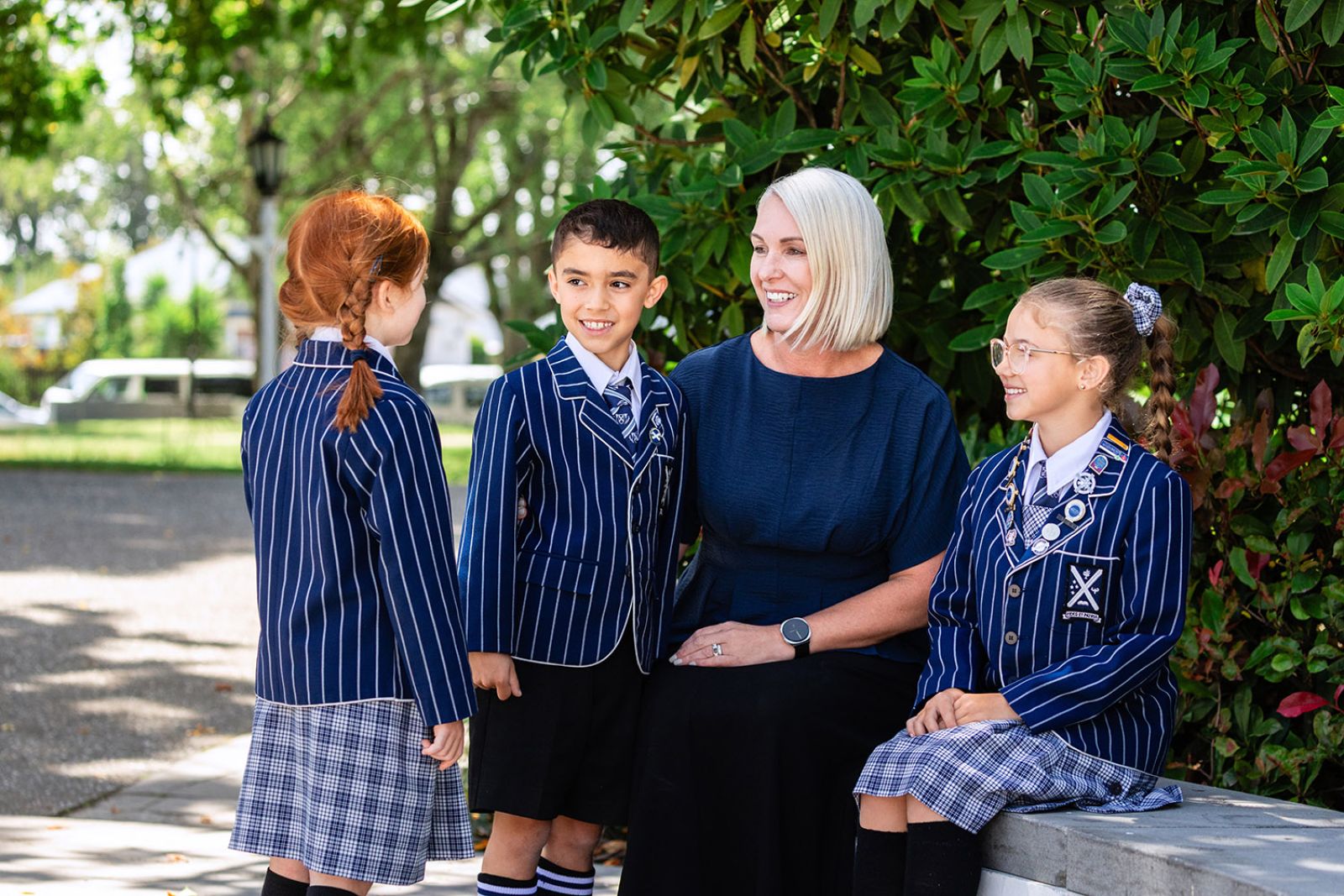 St Andrew's College Principal of Preparatory School sitting with three students