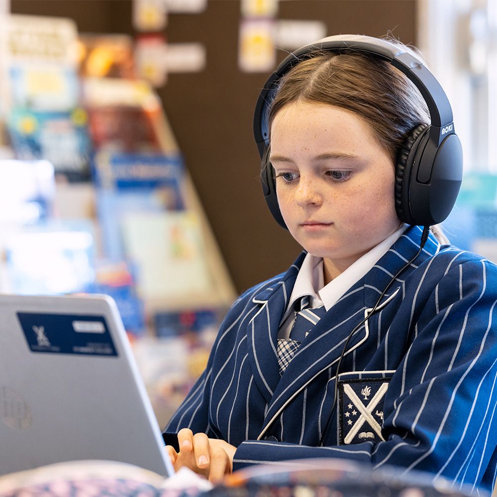 Preparatory student on a laptop with headphones.