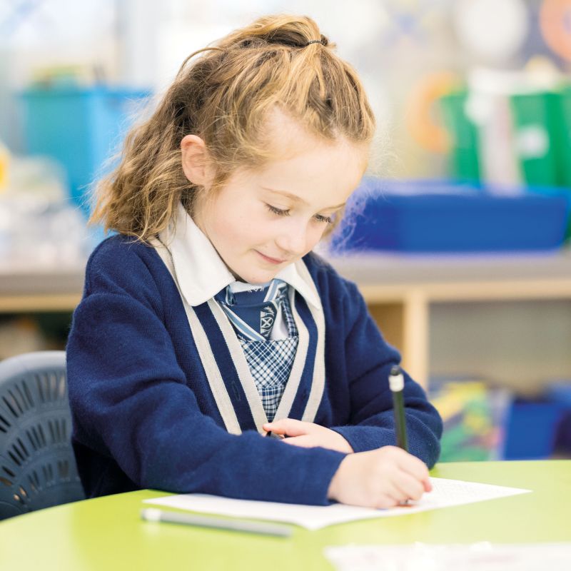 Preparatory student sat at desk writing