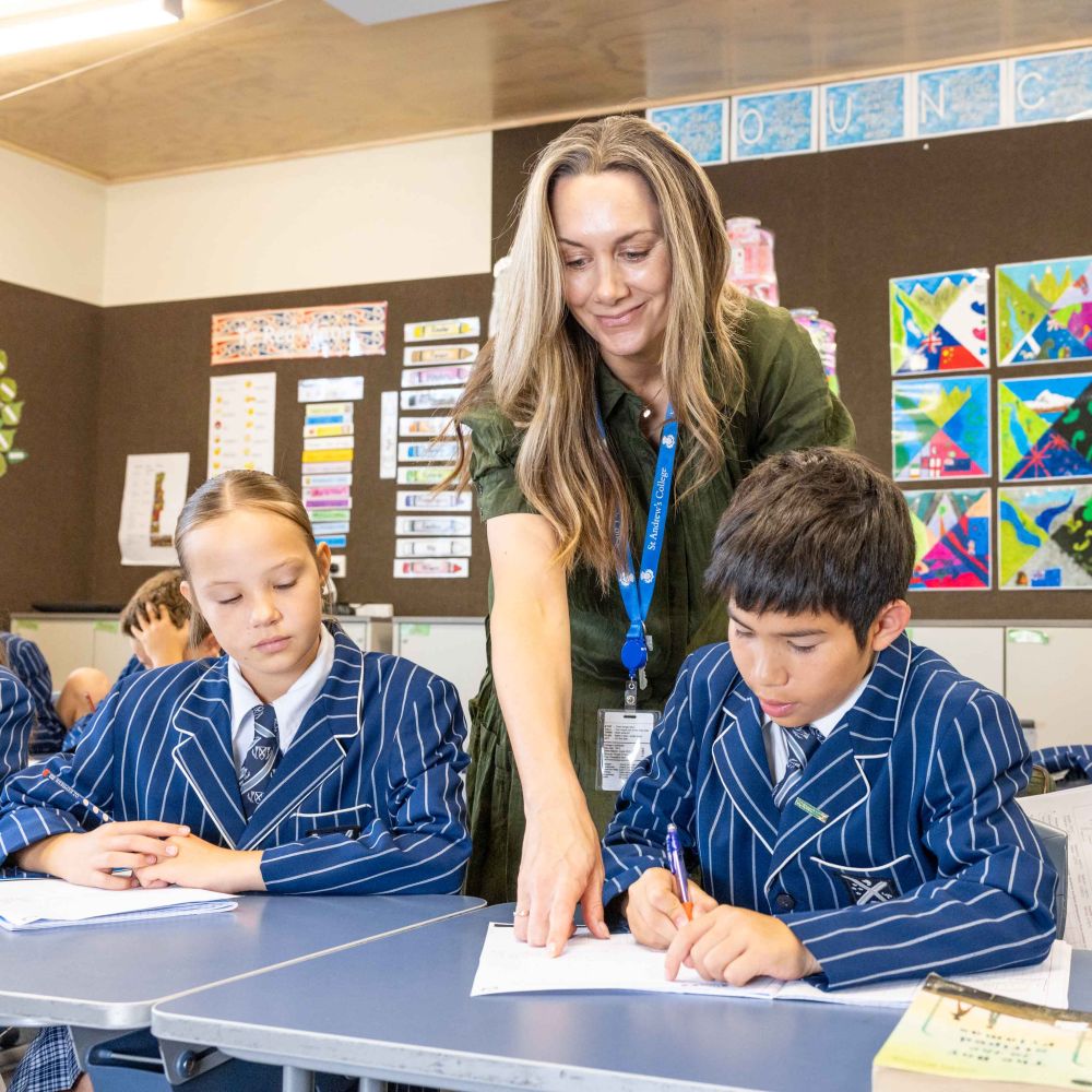 St Andrew's College teacher working with two Preparatory School students