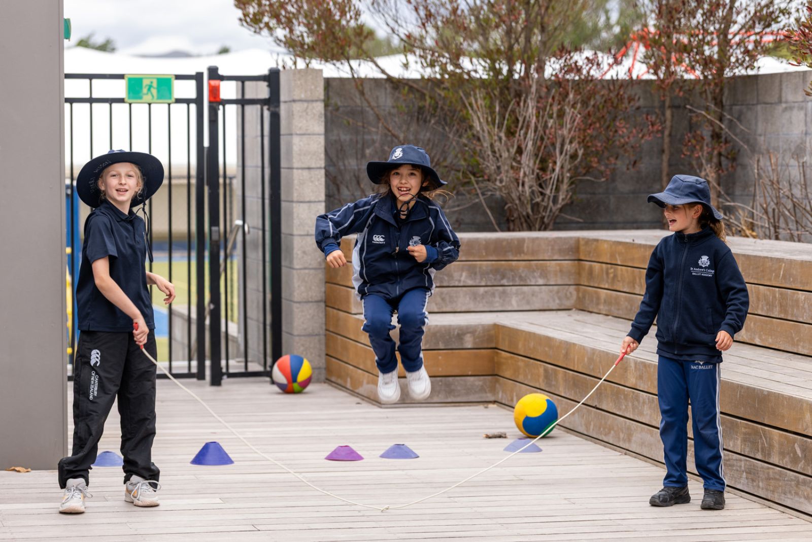 Three St Andrew's Collge Preparatory School students jumping a rope.
