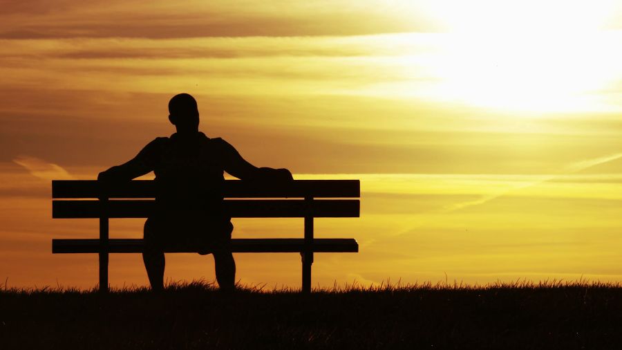 silhouette of a man sitting on a bench