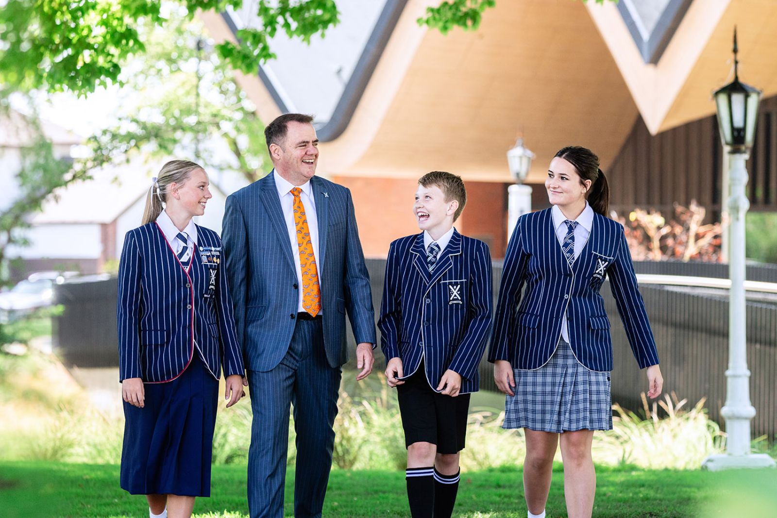 St Andrew's College Rector walking on campus with three students